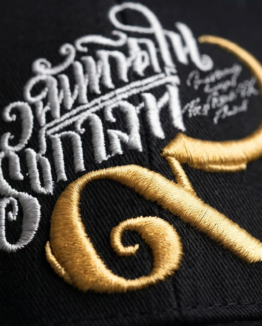 Black Script and Gold Emblem Baseball Cap